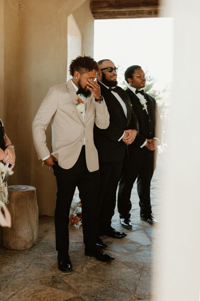 A groom expressing tears of happiness during an intimate wedding ceremony at Chapel Dulcinea in Austin, Texas, on a sunny day, with clear skies and natural surroundings.