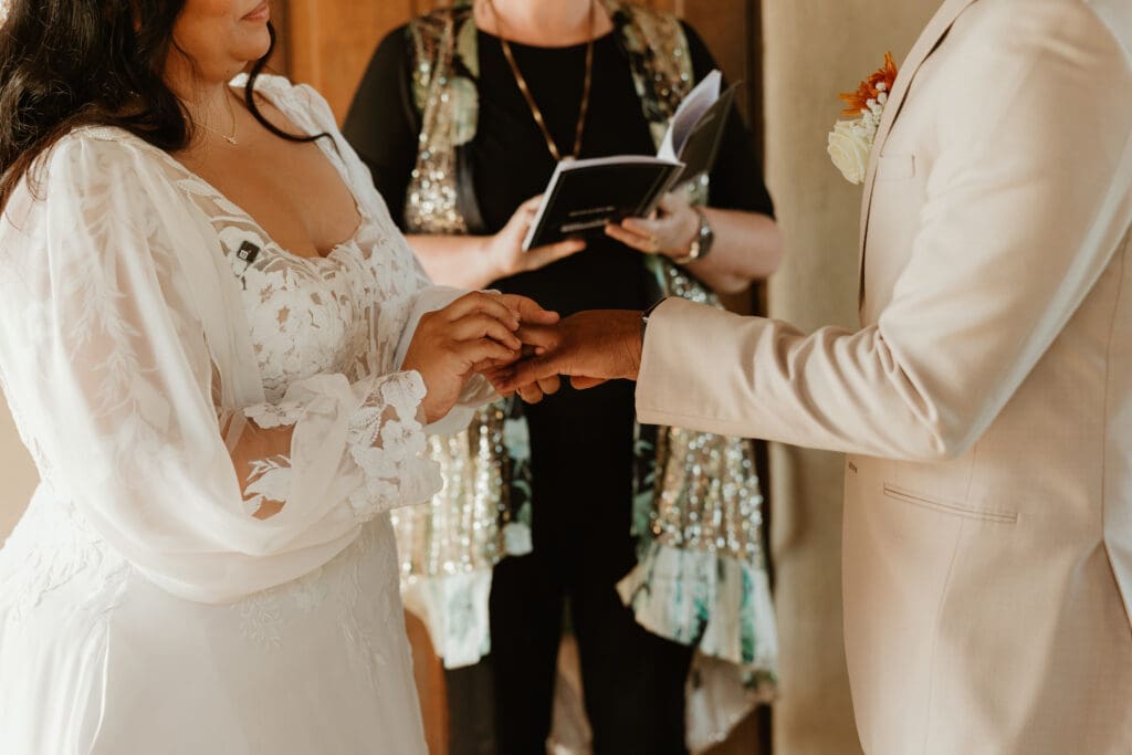 A couple having an intimate wedding ceremony, exchanging rings, at Chapel Dulcinea in Austin, Texas.