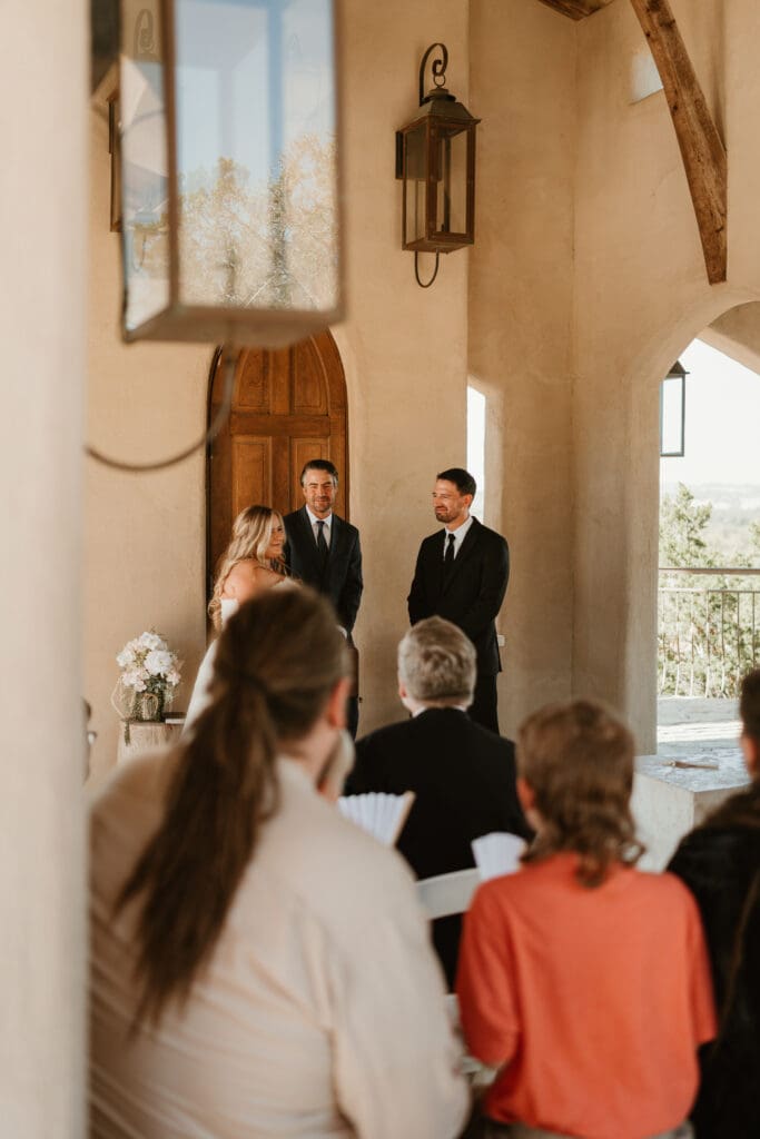 A couple having an intimate wedding ceremony at Chapel Dulcinea in Austin, Texas, on a sunny day surrounded by friends and family.