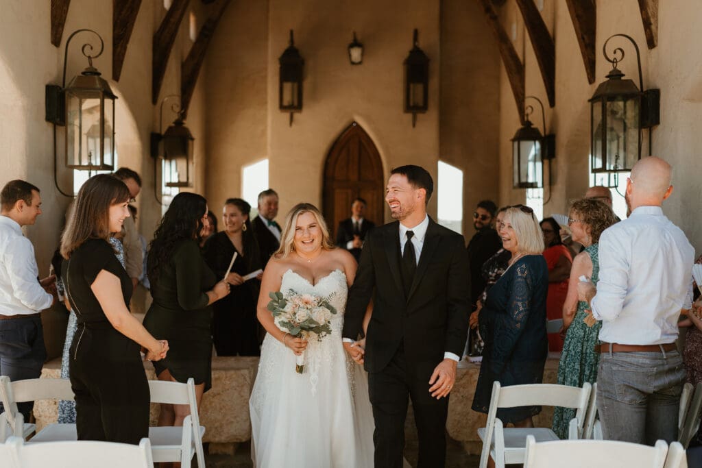 A couple having an intimate wedding ceremony at Chapel Dulcinea in Austin, Texas, on a sunny day surrounded by friends and family.