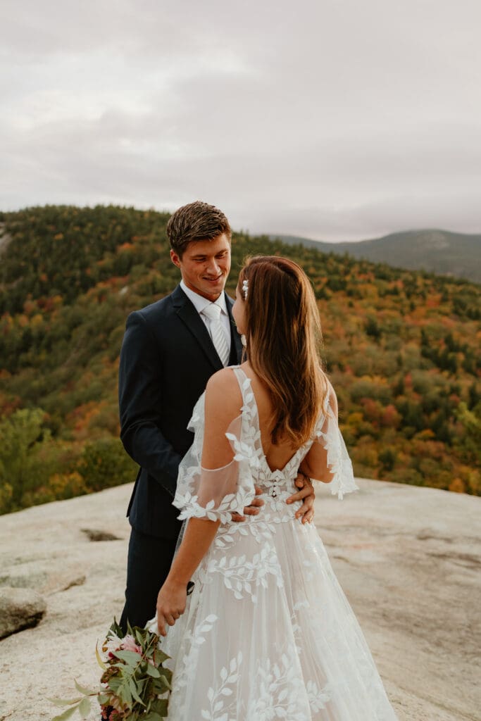 A couple eloping on a cloudy autumn evening in the mountains of New Hampshire, surrounded by colorful fall foliage.