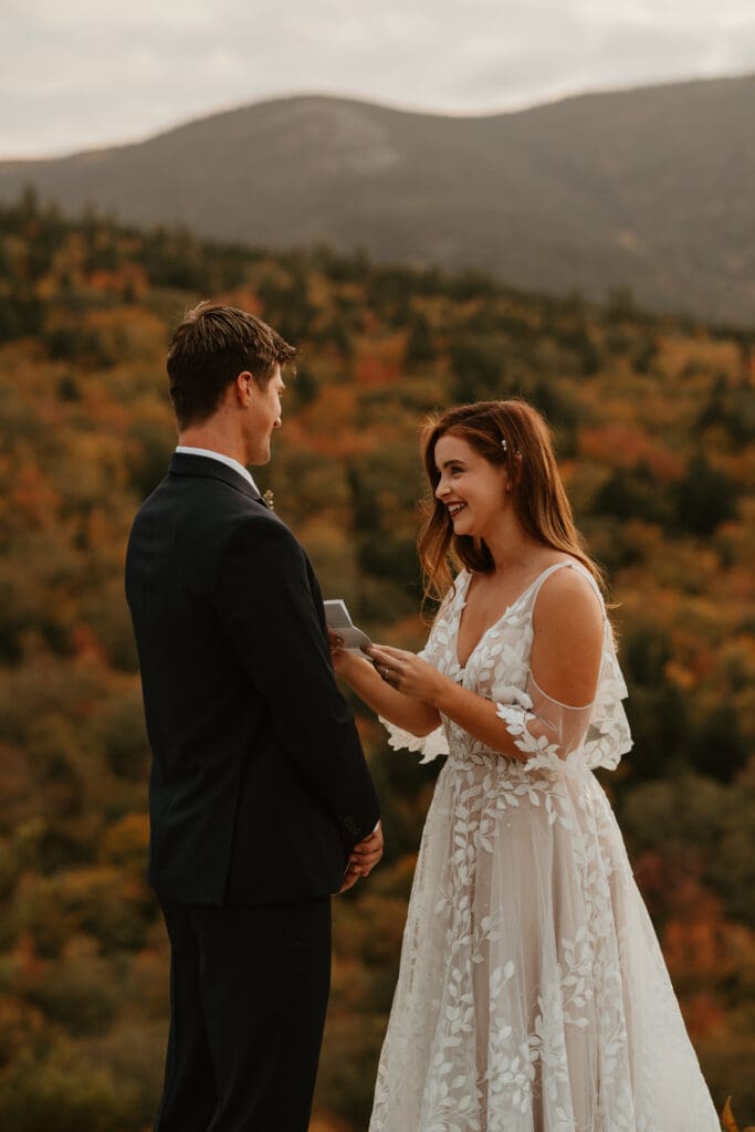 A couple eloping on a cloudy autumn evening in the mountains of New Hampshire, surrounded by colorful fall foliage.