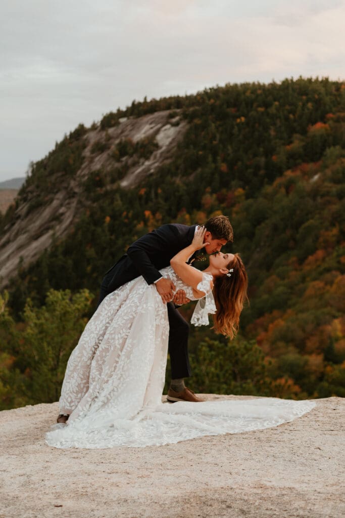 A couple eloping on a cloudy autumn evening in the mountains of New Hampshire, surrounded by colorful fall foliage.