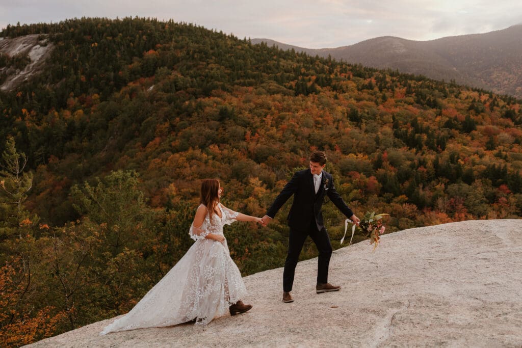 A couple eloping on a cloudy autumn evening in the mountains of New Hampshire, surrounded by colorful fall foliage.