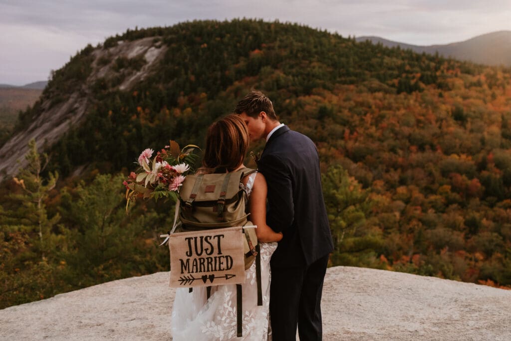 A couple eloping on a cloudy autumn evening in the mountains of New Hampshire, surrounded by colorful fall foliage.