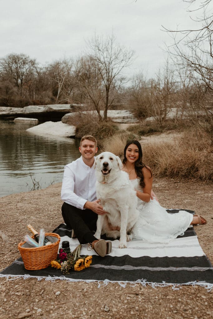 An engaged couple with their dog at McKinney Falls State Park in Austin, Texas.