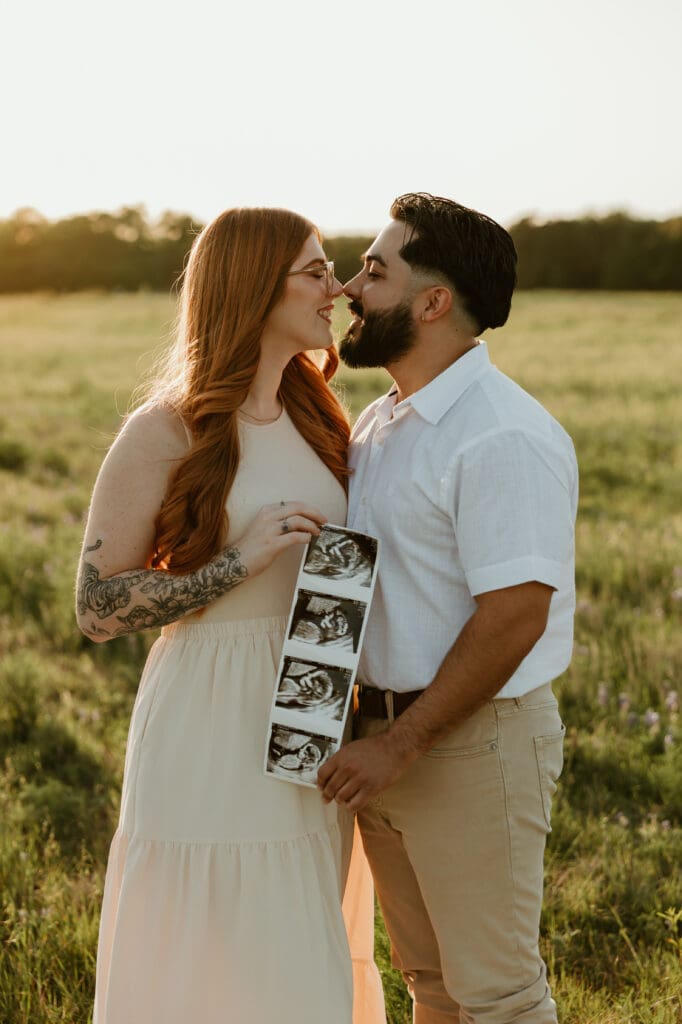 Couple going in for a kiss with golden light shining through the background during photo session at Brushy Creek Lake Park in Cedar Park, Texas. 