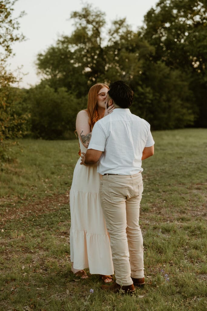 Emotional proposal moment captured at Brushy Creek Lake Park, surrounded by trees and the setting sun. 