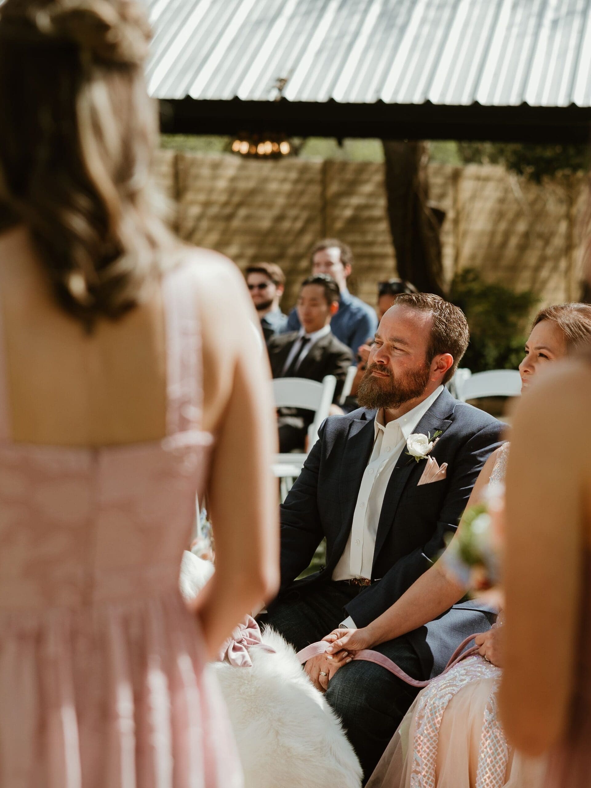 Bride's father watching his daughter exchange vows during their outdoor garden ceremony at The Hummingbird House in Central Texas
