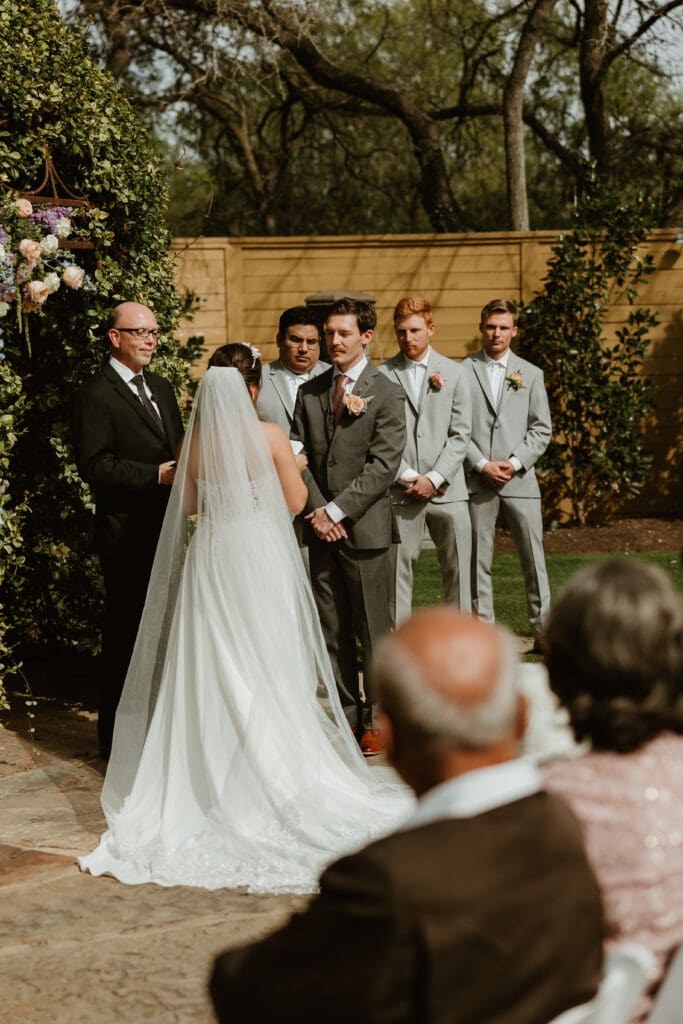 Groom admiring his bride during their outdoor wedding ceremony at The Hummingbird House in Central Texas