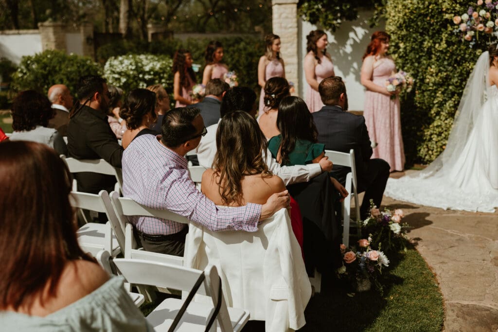 Guests happily watching wedding ceremony in outdoor seating at The Hummingbird House near Austin TX