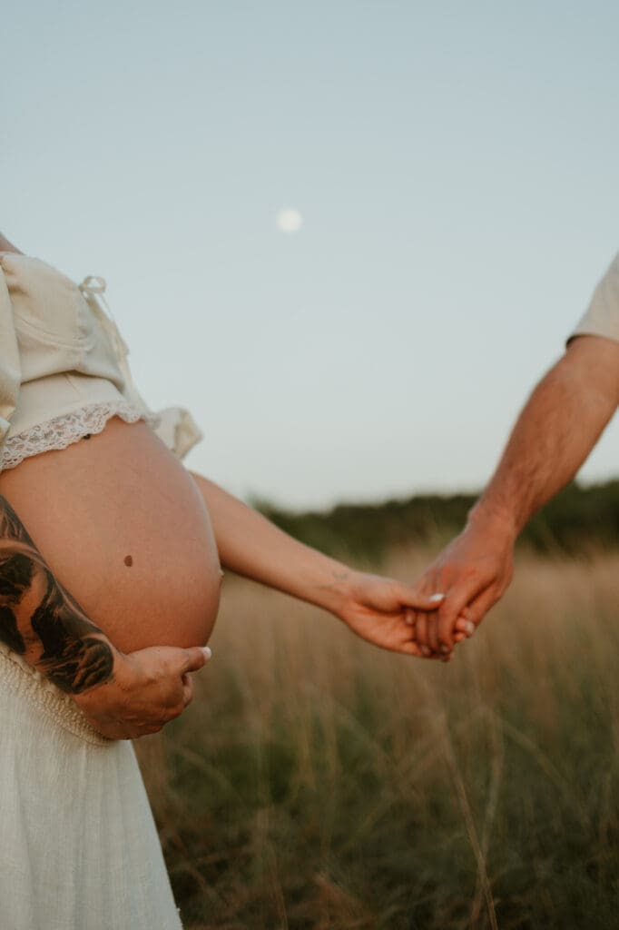 Close up of baby bump in tall grassy field in Austin, Texas. 