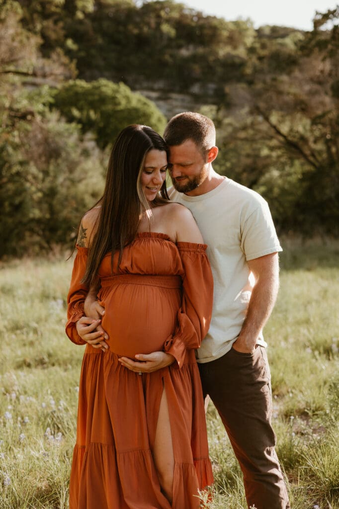 Expecting parents hold baby bump during maternity photoshoot in Austin. 