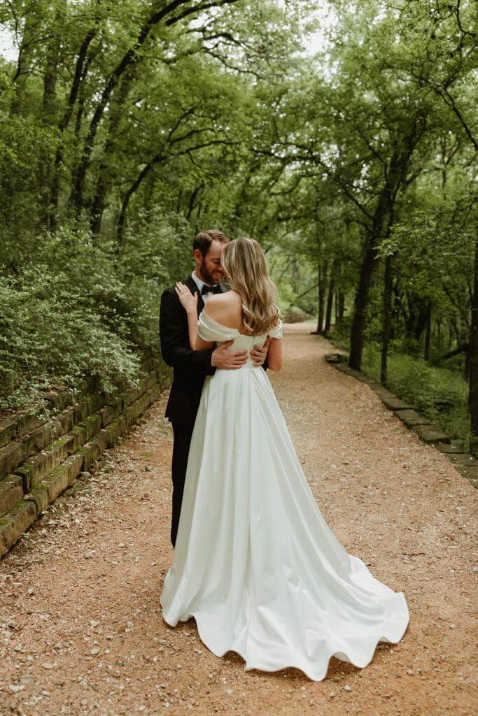 Outdoor bride and groom portraits in lush pathway during Spring in Austin Texas