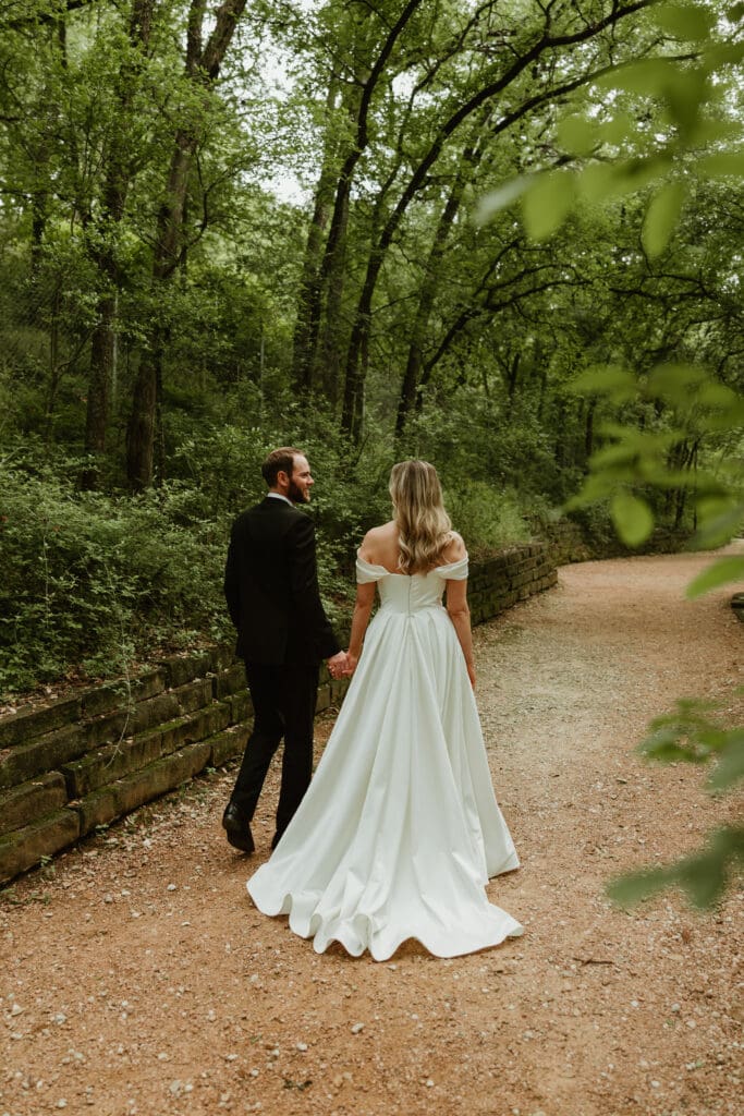 Bride and groom take a walk in lush pathway during Spring in Austin Texas