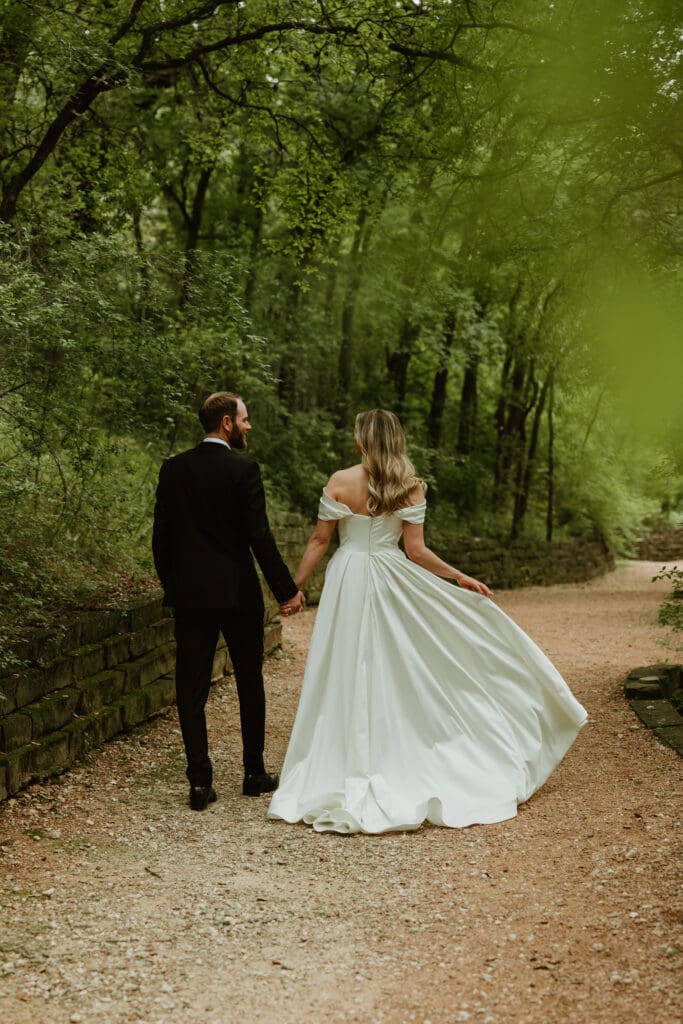 Bride and groom take a walk in lush pathway during Spring in Austin Texas