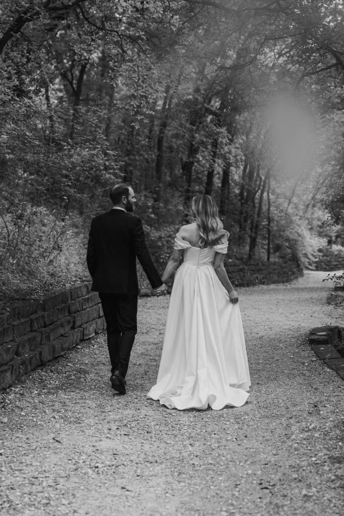 Bride and groom take a walk in lush pathway during Spring in Austin Texas
