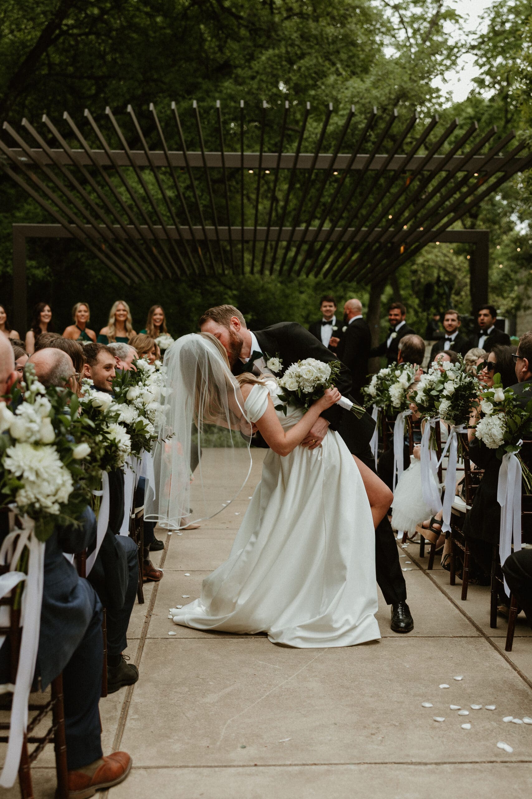 Bride and groom dip kiss at Umlauf Sculpture Garden wedding in Austin