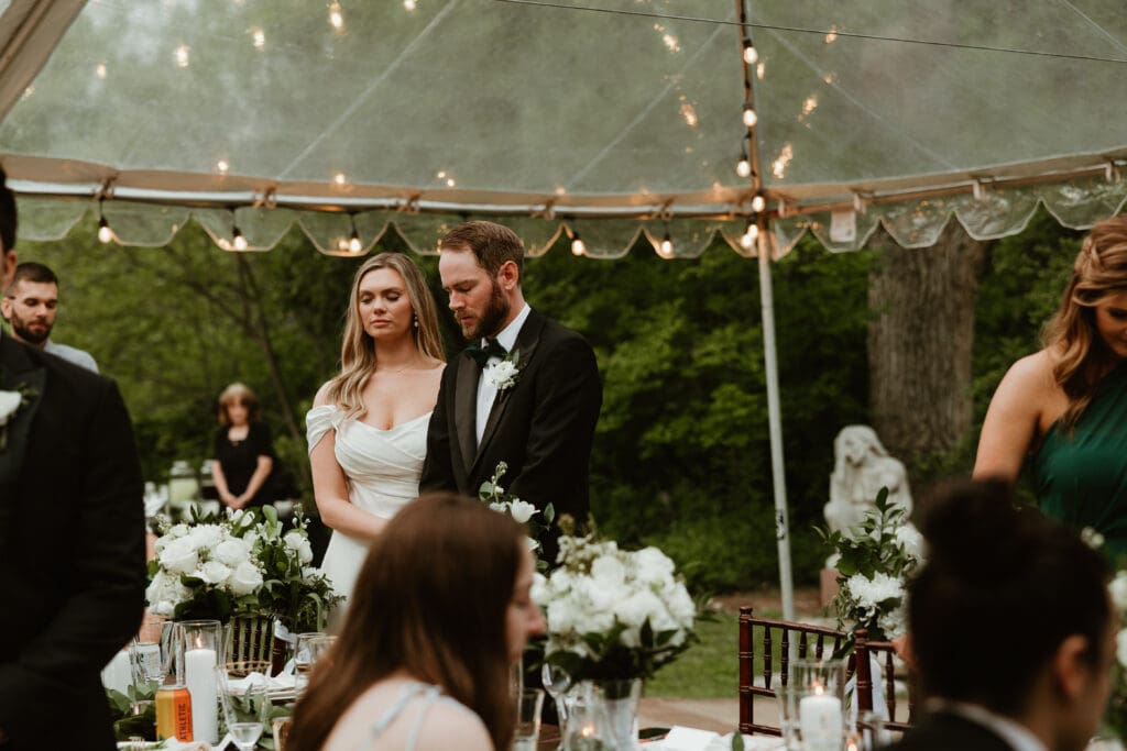 Bride and groom embracing prayer at Umlauf Sculpture Garden in Austin Texas