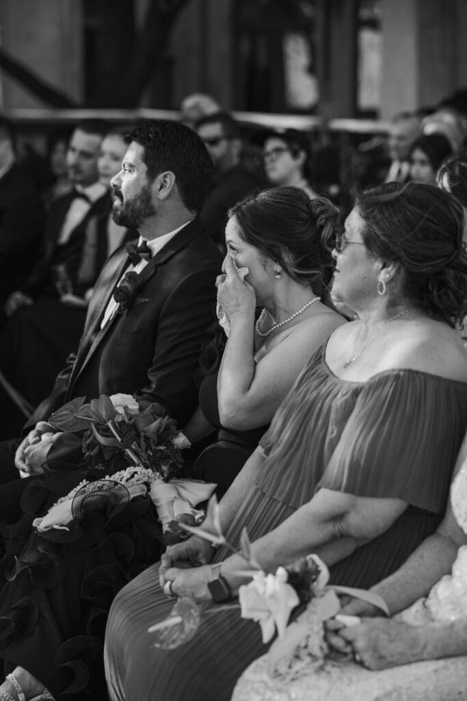 Mother of the bride wiping tears while watching her daughter exchange vows at Villa Antonia
