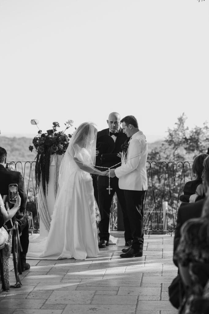 Bride and groom say a prayer on Villa Antonia terrace in Austin, Texas.