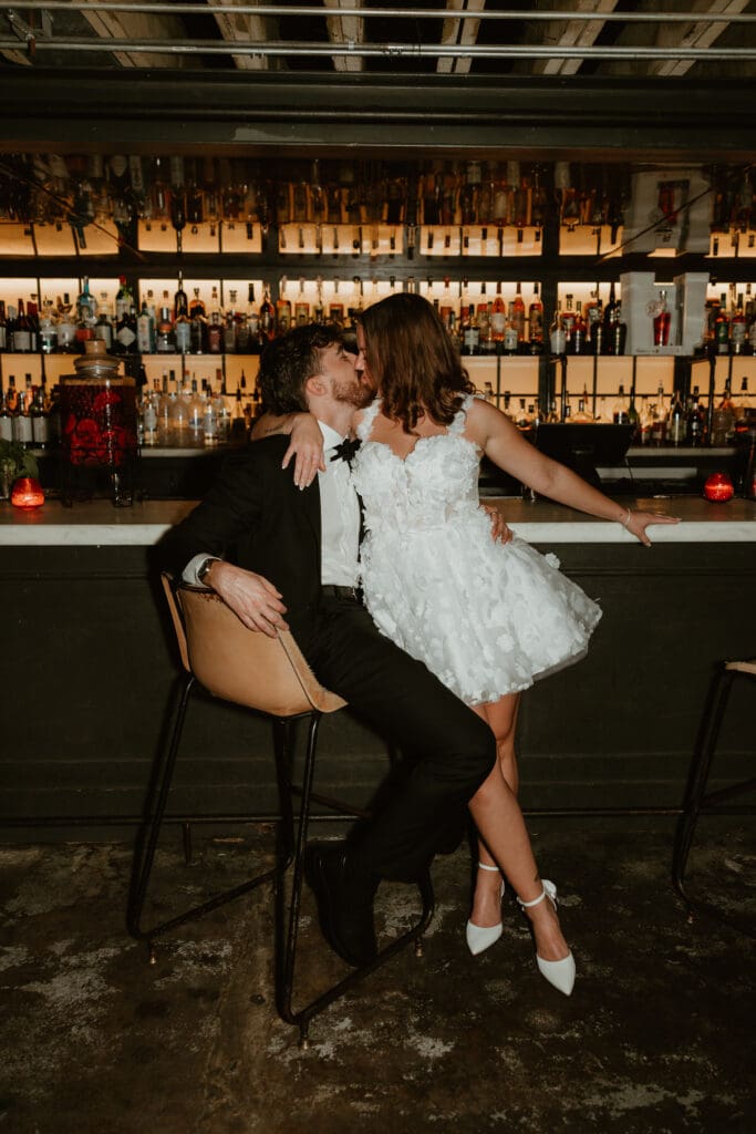 Engaged couple share a kiss in downtown Austin bar