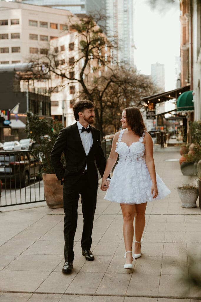 Engaged couple walk the street in busy downtown Austin 4th street